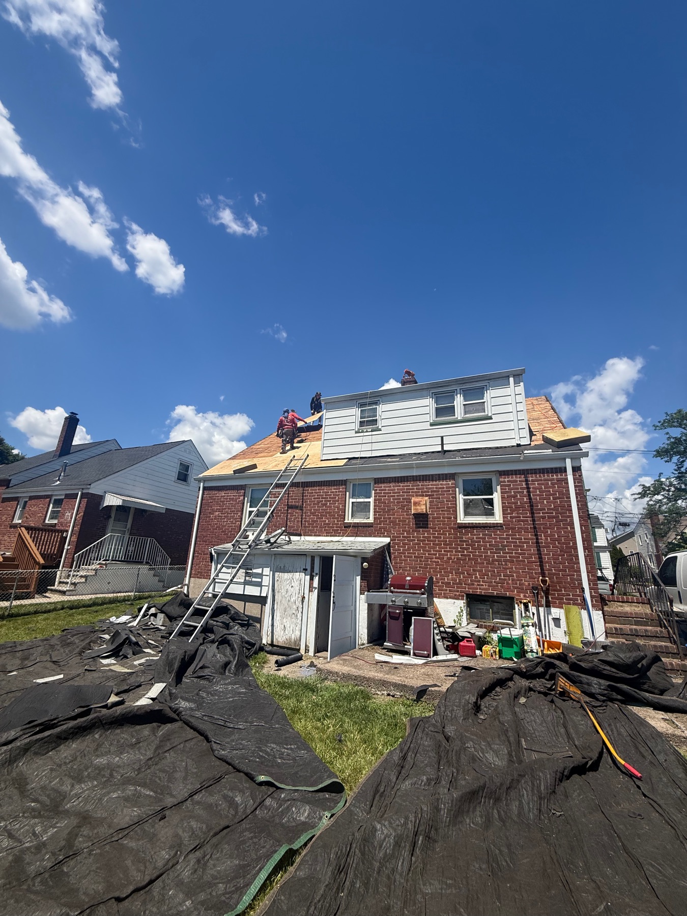 Roof tear-off with the yard tarped for property protection during a Clifton, NJ reroof