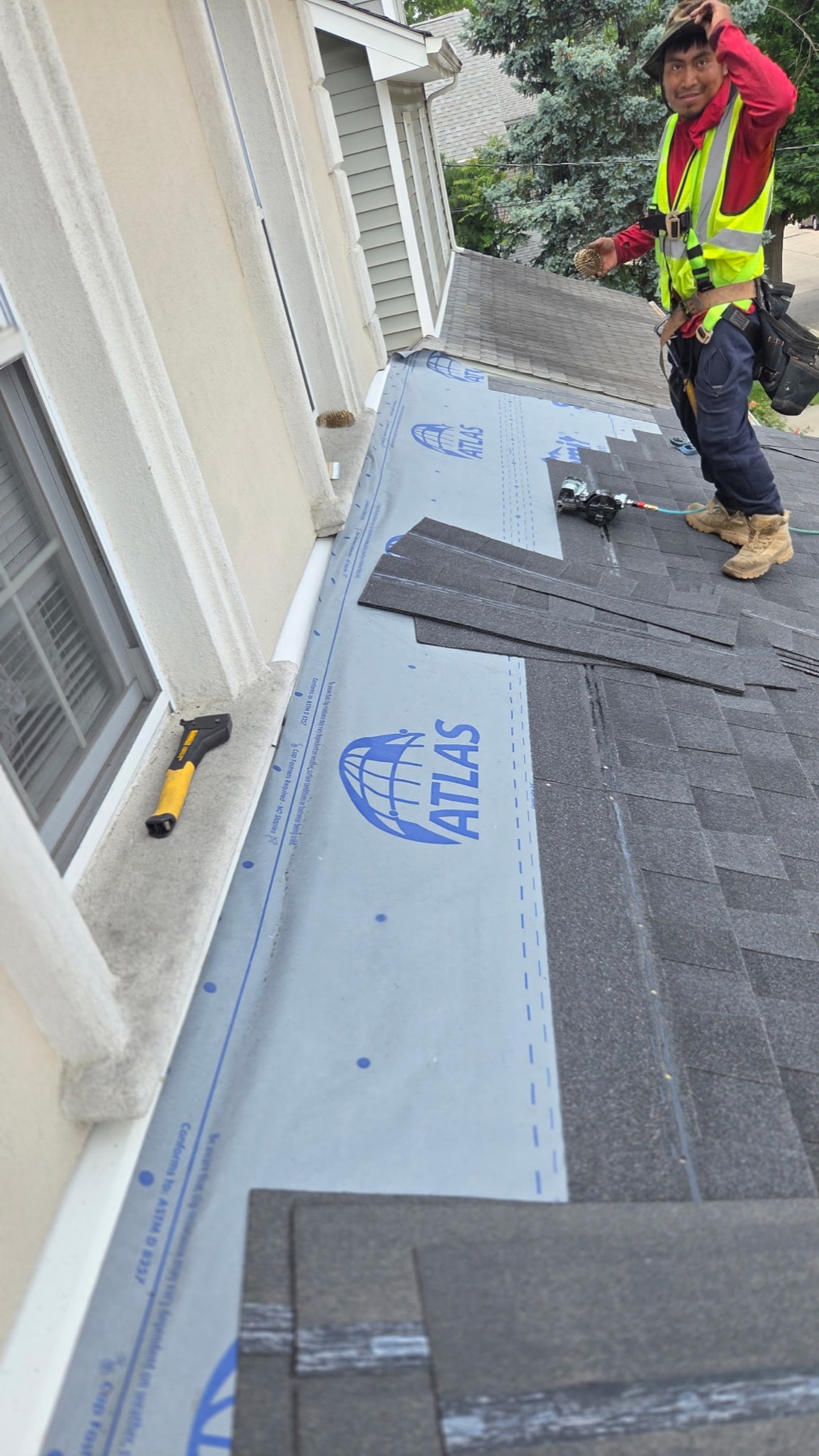Roofer installing charcoal architectural shingles over Atlas underlayment on a roof replacement in Richwood, NJ