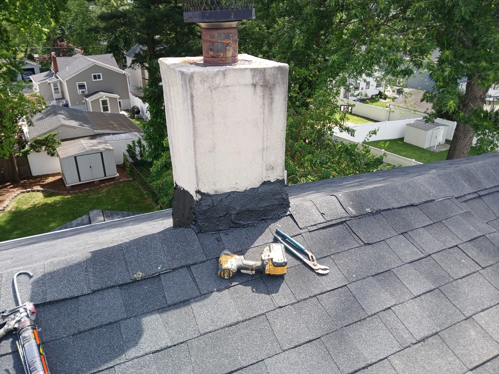 Rebuilt chimney flashing sealed into a newly installed charcoal architectural shingle roof in Richwood, NJ